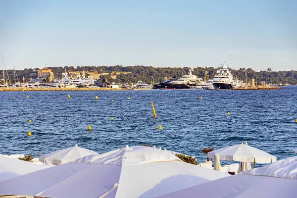 Baía do mar com iates barcos e guarda-chuva de praia em Cannes — Fotografia de Stock