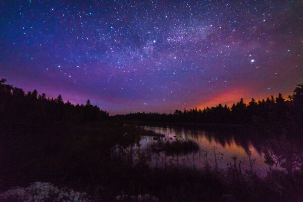 Night sky background with stars reflecting on Lake Huron