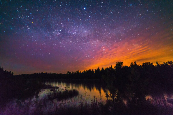 Night sky background with stars reflecting on Lake Huron