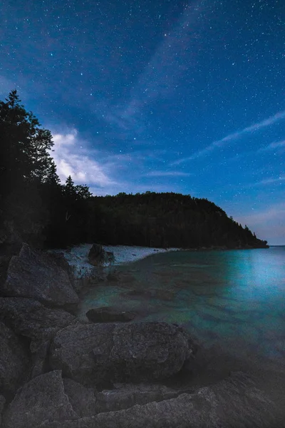 Vía Láctea y cielo estrellado con nubes a lo largo de la orilla del lago o —  Fotos de Stock