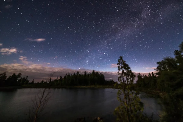 Lago y árboles bajo las estrellas a la luz de la luna — Foto de Stock