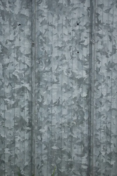 Grungy old galvanized steel panels on a barn with large pattern wallpaper backdrop