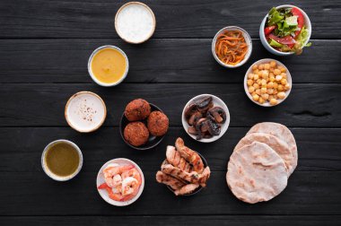 Farklı soslar ve siyah ahşap masa bulaşık sırası kümesi. Üstten görünüm