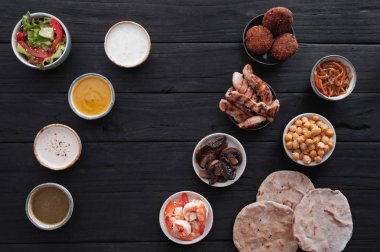 Farklı soslar ve siyah ahşap masa bulaşık sırası kümesi. Üstten görünüm