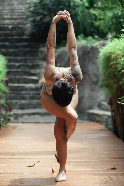 Sabah parkında yoga yapan genç bir kadın.