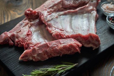 Koyu ahşap artalan üzerinde çiğ domuz kaburga