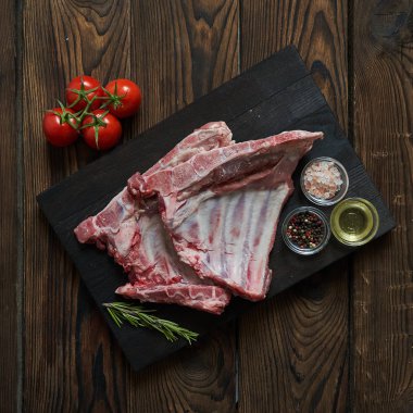 Koyu ahşap artalan üzerinde çiğ domuz kaburga. Yukarıdan görüntülemek