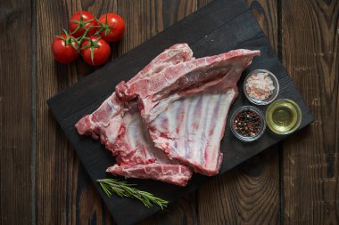 Koyu ahşap artalan üzerinde çiğ domuz kaburga. Yukarıdan görüntülemek