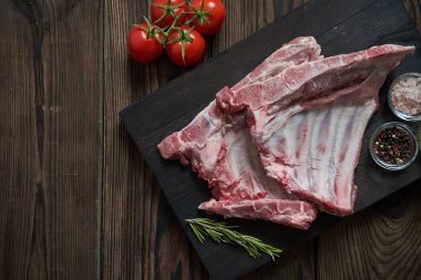 Koyu ahşap artalan üzerinde çiğ domuz kaburga. Yukarıdan görüntülemek