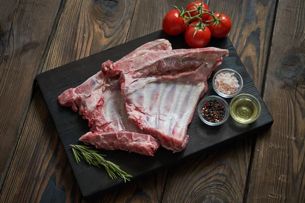 Koyu ahşap artalan üzerinde çiğ domuz kaburga