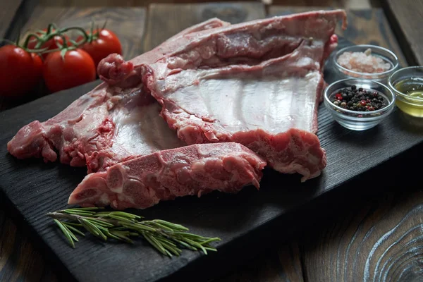 Koyu ahşap artalan üzerinde çiğ domuz kaburga