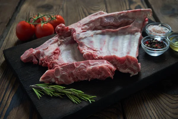 Koyu ahşap artalan üzerinde çiğ domuz kaburga