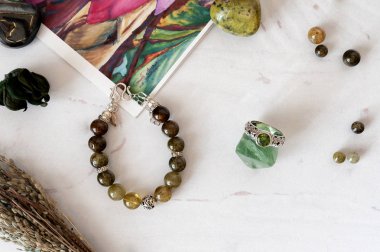 Doğal taş ve gümüş yapılmış bilezikler. Düz düşürür ve aksesuarları ile yatıyordu. Yukarıdan görüntülemek