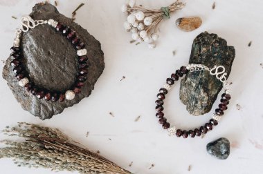 Doğal taş ve gümüş yapılmış bilezikler. Düz düşürür ve aksesuarları ile yatıyordu. Yukarıdan görüntülemek