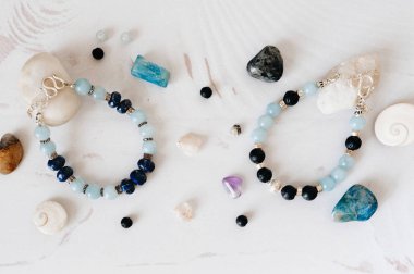 Doğal taş ve gümüş yapılmış bilezikler. Düz düşürür ve aksesuarları ile yatıyordu. Yukarıdan görüntülemek