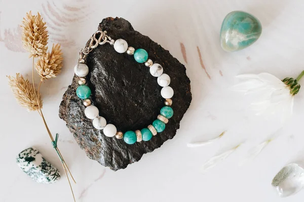 Doğal taş ve gümüş yapılmış bilezikler. Düz düşürür ve aksesuarları ile yatıyordu. Yukarıdan görüntülemek