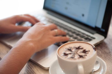 Sarışın genç kadın serbest meslek kafede dizüstü bilgisayar yazmaya