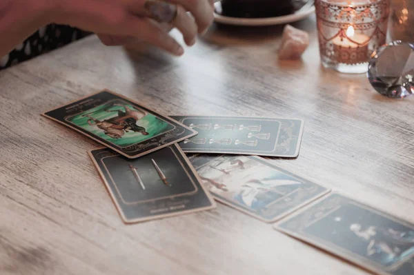 Kadın kafede masada Tarot kartları okuyor.