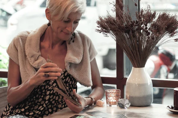 Μια Γυναίκα Διαβάζει Κάρτες Ταρώ Στο Τραπέζι Στο Καφέ — Φωτογραφία Αρχείου