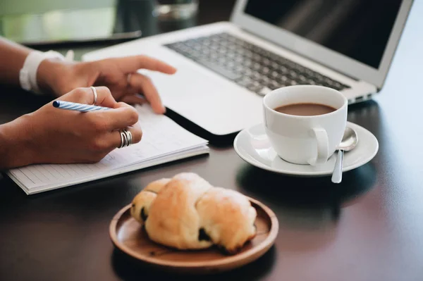 Junge Geschäftsfrau sitzt im Café und macht sich Notizen in Notizbuch. — Stockfoto