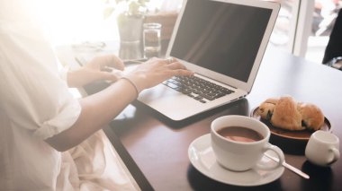 Genç kadın öğrenci kafede oturan ve laptop ile çalışan dizüstü bilgisayar ile. Görünümü kapatın