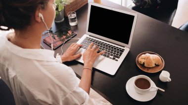 Genç kadın öğrenci kafede oturan ve laptop ile çalışan dizüstü bilgisayar ile