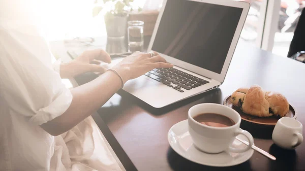 Genç kadın öğrenci kafede oturan ve laptop ile çalışan dizüstü bilgisayar ile. Görünümü kapatın