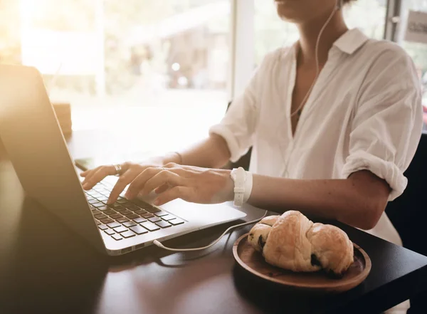 カフェに座っていると 朝食を持っているノート パソコンでの作業はノート パソコンで若い女性学生 — ストック写真