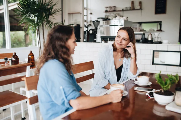 Vrolijke Vriendinnen Chatten Café Twee Mooie Jonge Vrouwen Roddelen Drinken — Stockfoto