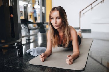 Çekici genç kadın spor salonunda tahta egzersiz yapıyor