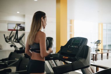 Koşu bandında koşan genç kadın