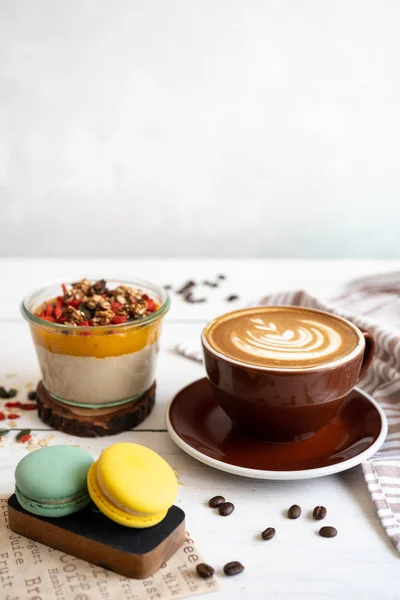 Вкусный завтрак на столе. Чашка кофе, манго пудинг и макароны за белым столом . — стоковое фото