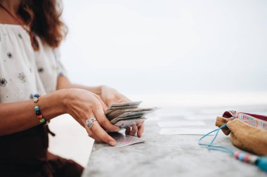 Kadın plajda Tarot kartları okuyor
