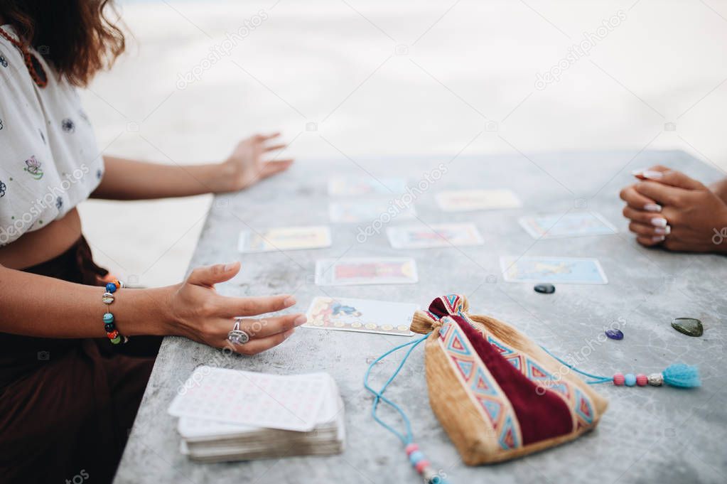 Woman is reading Tarot cards at the beach