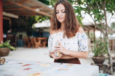 Kadın plajda Tarot kartları okuyor