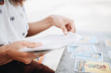 Kadın plajda Tarot kartları okuyor