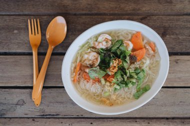 Ahşap masada Tay Noodle çorba plakası.