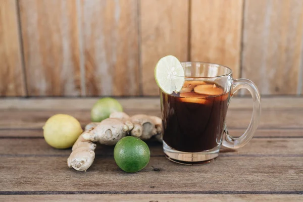 Świeża zimna herbata z limonką, miętową i cytrynową na drewnianym stole — Zdjęcie stockowe