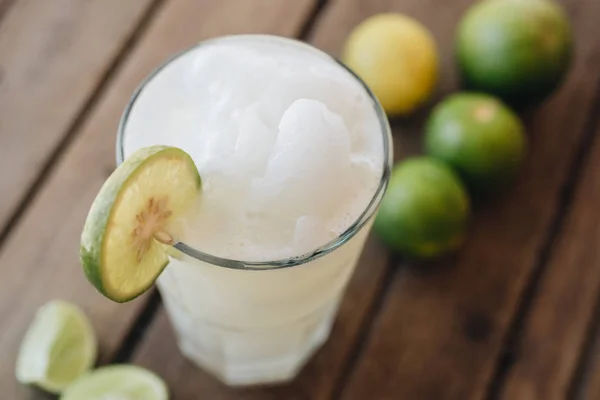 Kalkskakning i glas vid trä bakgrund — Stockfoto