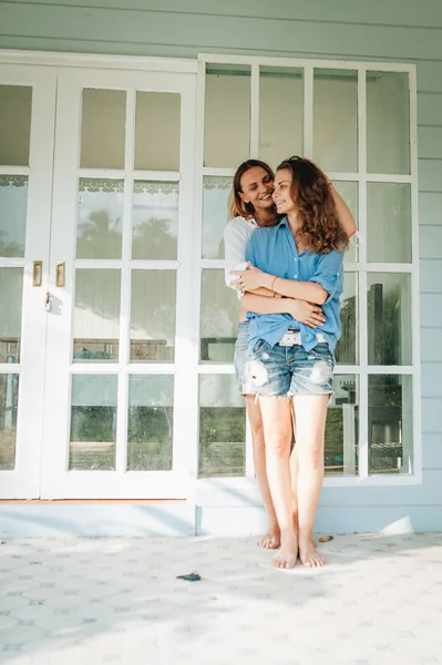 Felice coppia lesbica in piedi sulla terrazza alla loro casa di campagna — Foto Stock