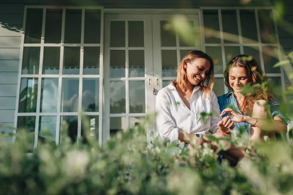 Felice coppia lesbica seduta sulla terrazza alla loro casa di campagna — Foto Stock