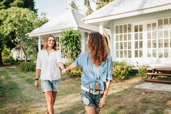 Felice coppia lesbica a piedi in giardino presso la loro casa di campagna — Foto Stock