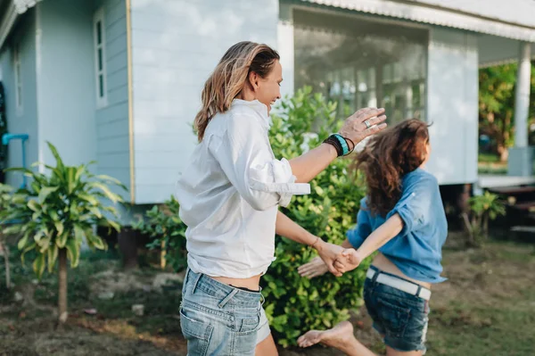 Happy lesbian couple walking in the garden at their country house — Stock Photo, Image