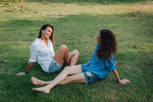 Счастливые женщины сидят на траве — стоковое фото