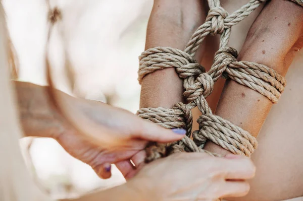 Woman bound with a rope in Japanese technique shibari outdoors — Stock Photo, Image