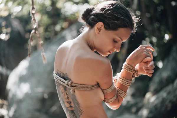 Kadın Japon tekniği shibari açık havada bir iple bağlı