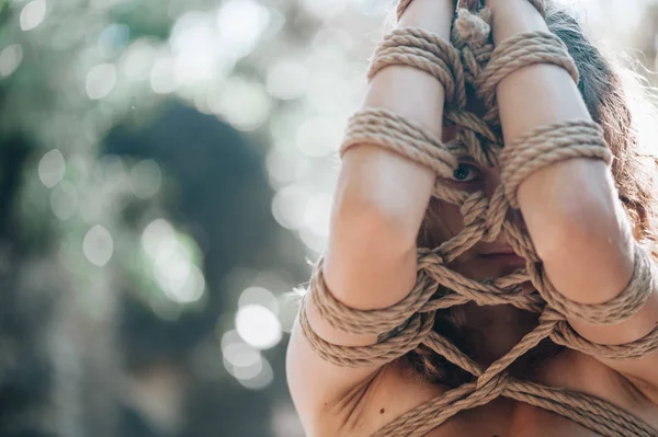 Kadın Japon tekniği shibari açık havada bir iple bağlı