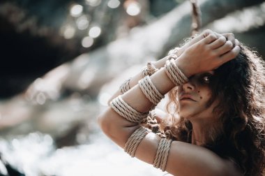 Kadın Japon tekniği shibari açık havada bir iple bağlı