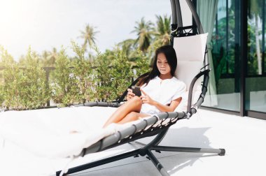 Dışarıda telefonla konuşan genç bir kadın.