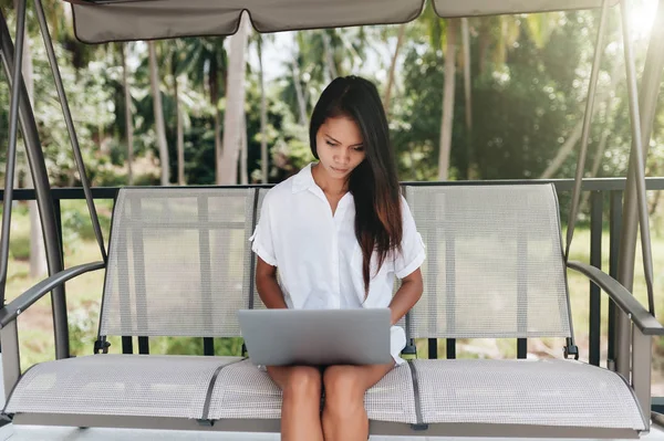 Молода жінка використовує ноутбук на відкритому повітрі — стокове фото